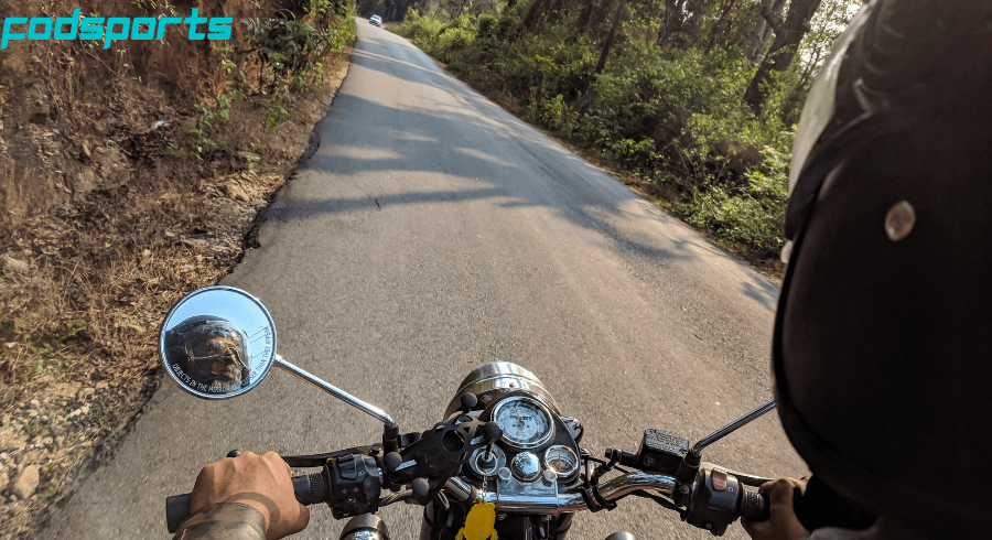 A motorcycle rider is about to meet a car, so he is very careful