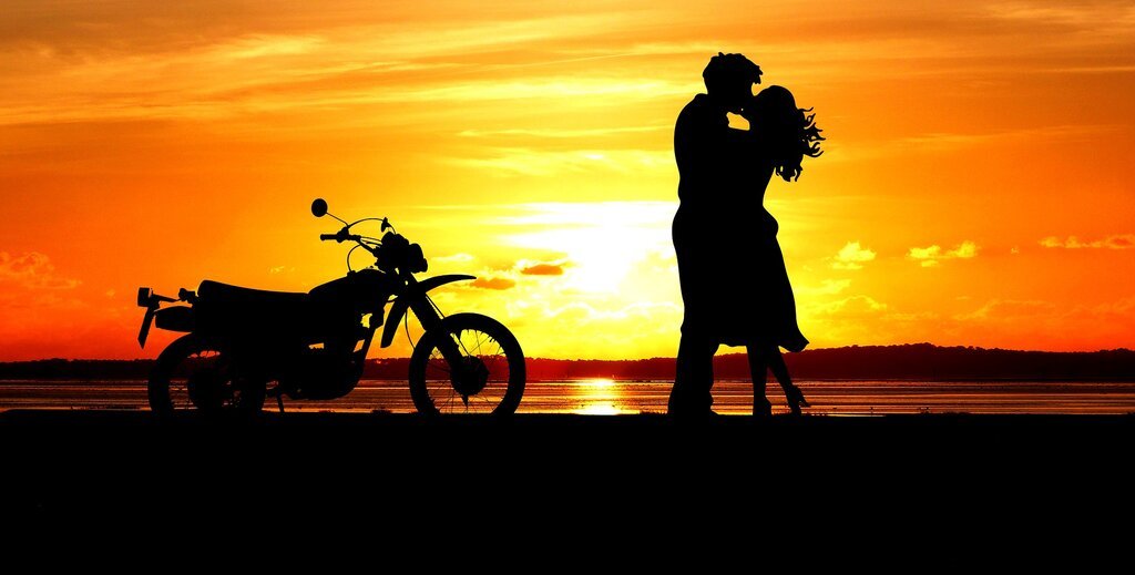 Couple and motorcycle in the sunset