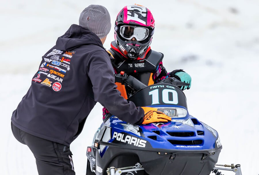 a father is communicating with a young snowmobiler