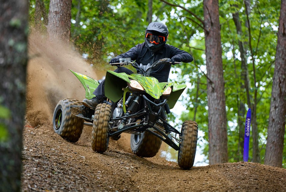 A sports ATV by Yamaha running in the forest trail