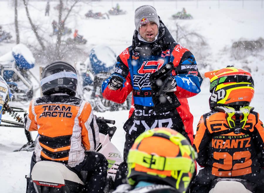 an adult is teaching the children snowmobiling safety rules